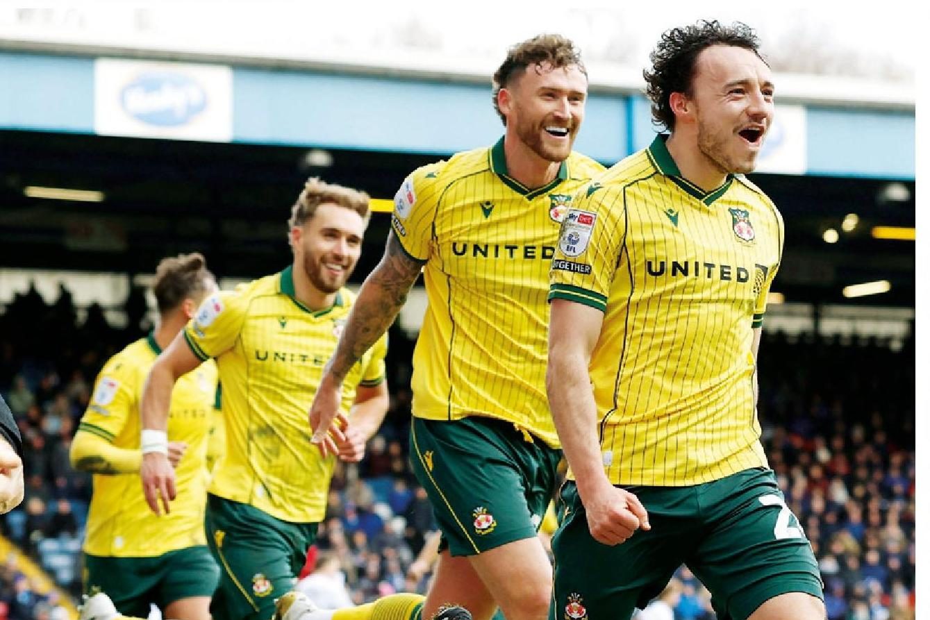 Oliver Rathbone celebrates with his Wrexham team-mates