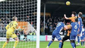 Kelland Watts heads in the third goal for Cambridge United
