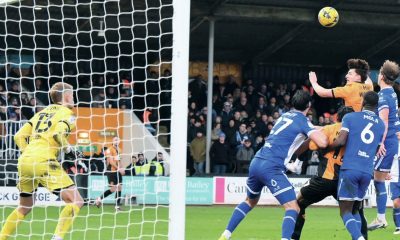 Kelland Watts heads in the third goal for Cambridge United
