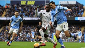 Manchester City’s Tijjani Reijnders holds off Salford City’s Rosaire Longelo