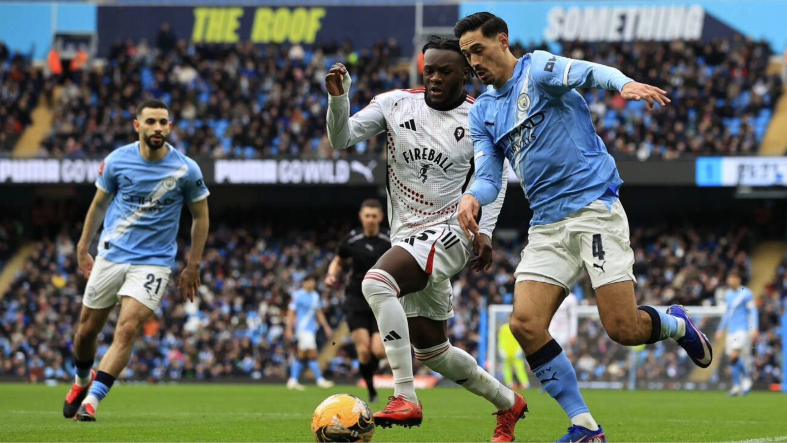 Manchester City’s Tijjani Reijnders holds off Salford City’s Rosaire Longelo