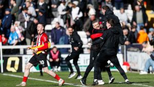 Lincoln City’s bench, and scorer Jack Moylan, celebrate