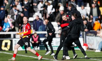 Lincoln City’s bench, and scorer Jack Moylan, celebrate