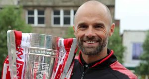Former Rotherham United manager Paul Warne holds aloft the League One play-off trophy
