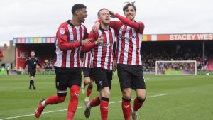 Lincoln City’s Jack Moylan, centre, celebrates scoring with team-mates Reeco Hackett, left, and Tom Bayliss, right.