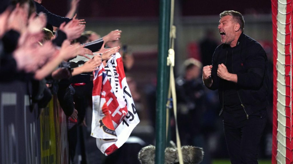 Salford City manager Karl Robinson celebrates with fans