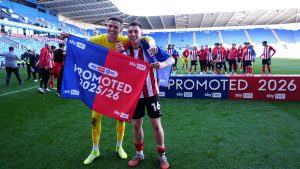 Lincoln City goalkeeper George Wickens and Dom Jefferies celebrate promotion