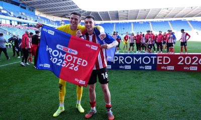 Lincoln City goalkeeper George Wickens and Dom Jefferies celebrate promotion