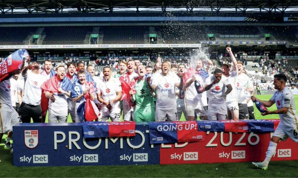 MK Dons players celebrate their promotion to League One