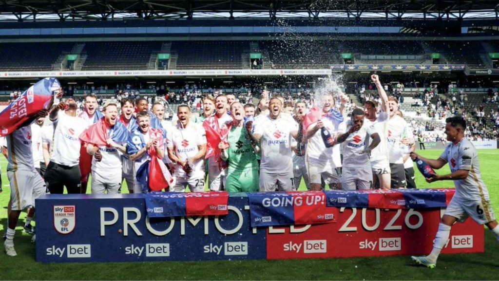 MK Dons players celebrate their promotion to League One