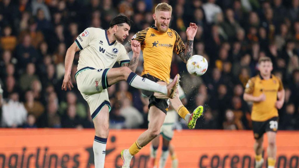 Millwall&rsquo;s Tristan Crama (left) and Hull City&rsquo;s Oli McBurnie battle for the ball