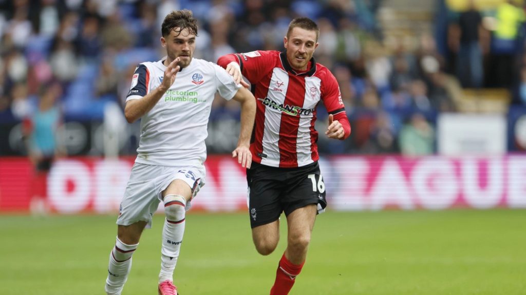 Bolton Wanderers’ Max Conway is chased by Lincoln City’s Dominic Jefferies