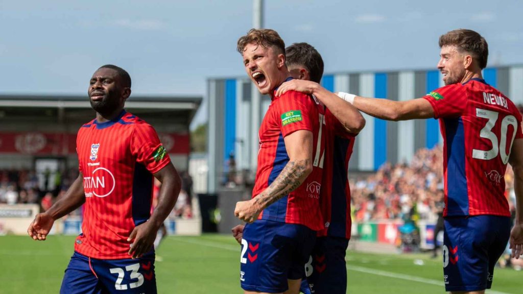 Harry Boyes celebrates his first York City goal with Alex Newby, right and Joe Felix, left.