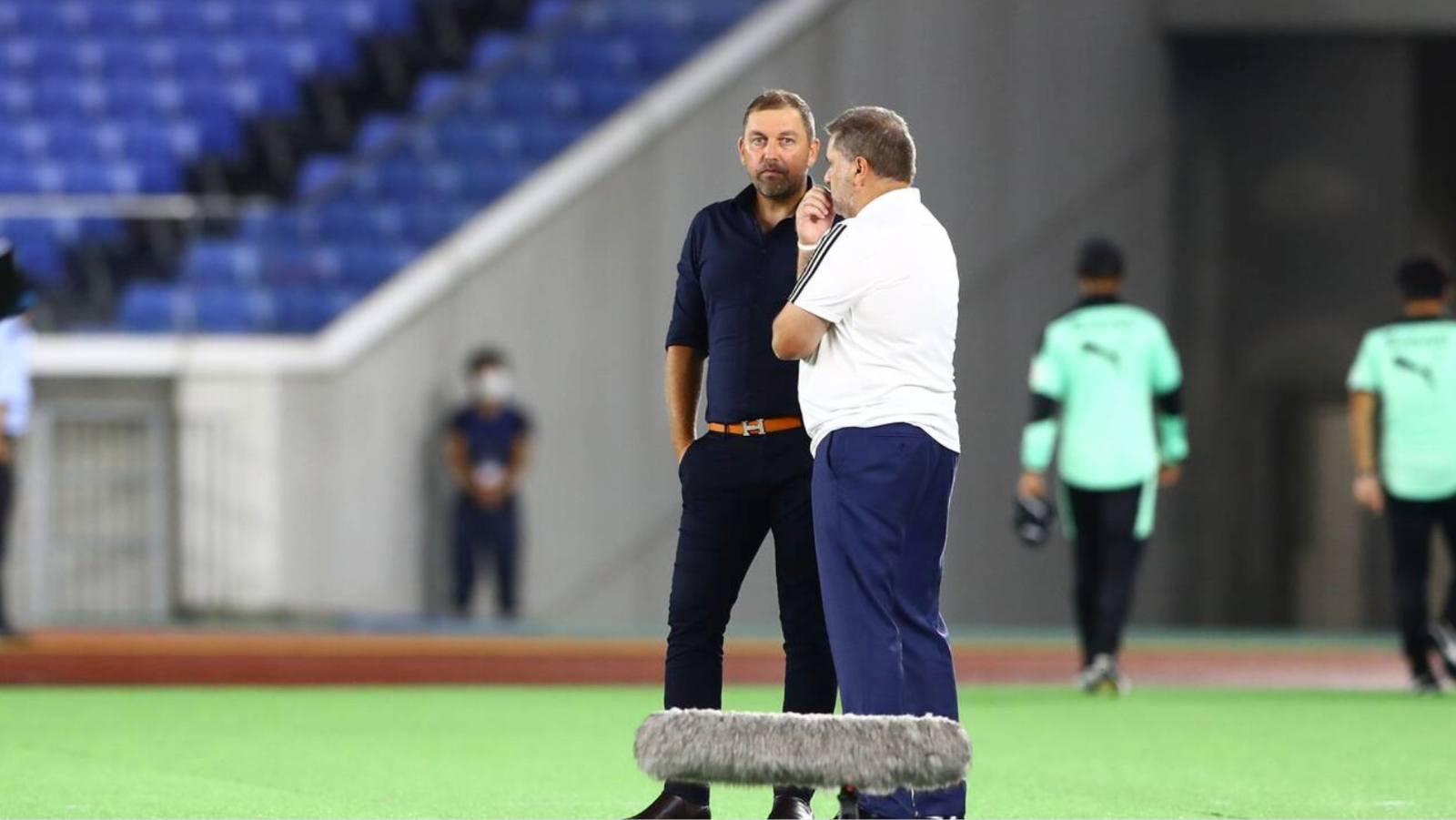 Peter Cklamovski, left, talks with Ange Postecoglou.