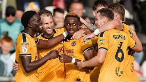 Shaquille Gwengwe, centre, takes the congratulations of his Newport County teammates.