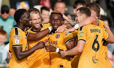 Shaquille Gwengwe, centre, takes the congratulations of his Newport County teammates.