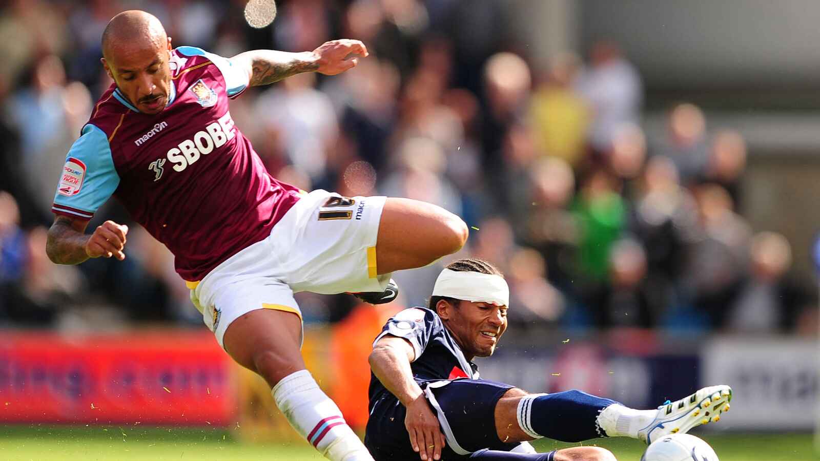 Millwall’s Tamika Mkandawire and West Ham United’s Julien Faubert battle for the ball at The Den in 2011