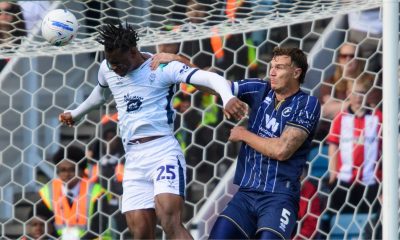 Lincoln City’s Deji Elerewe heads clear under pressure from Millwall defender Jake Cooper.