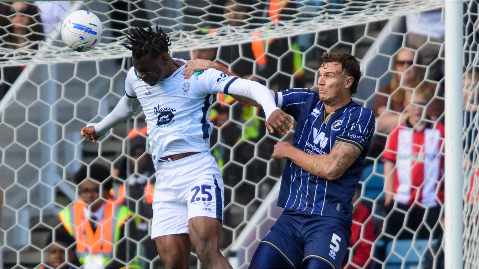 Lincoln City’s Deji Elerewe heads clear under pressure from Millwall defender Jake Cooper.