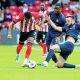 Wigan’s Morgan Fox, right, slides in to tackle Lincoln’s Reeco Hackett-Fairchild
