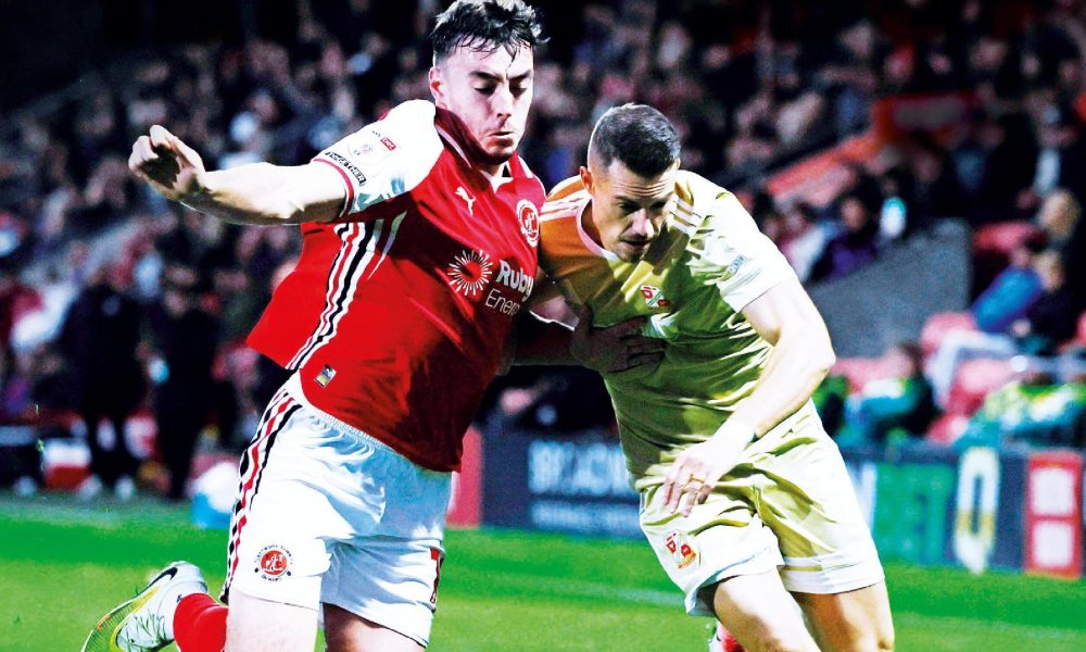 Fleetwood Town’s Harrison Holgate, left, and Swindon Town’s Billy Bodin fight it out