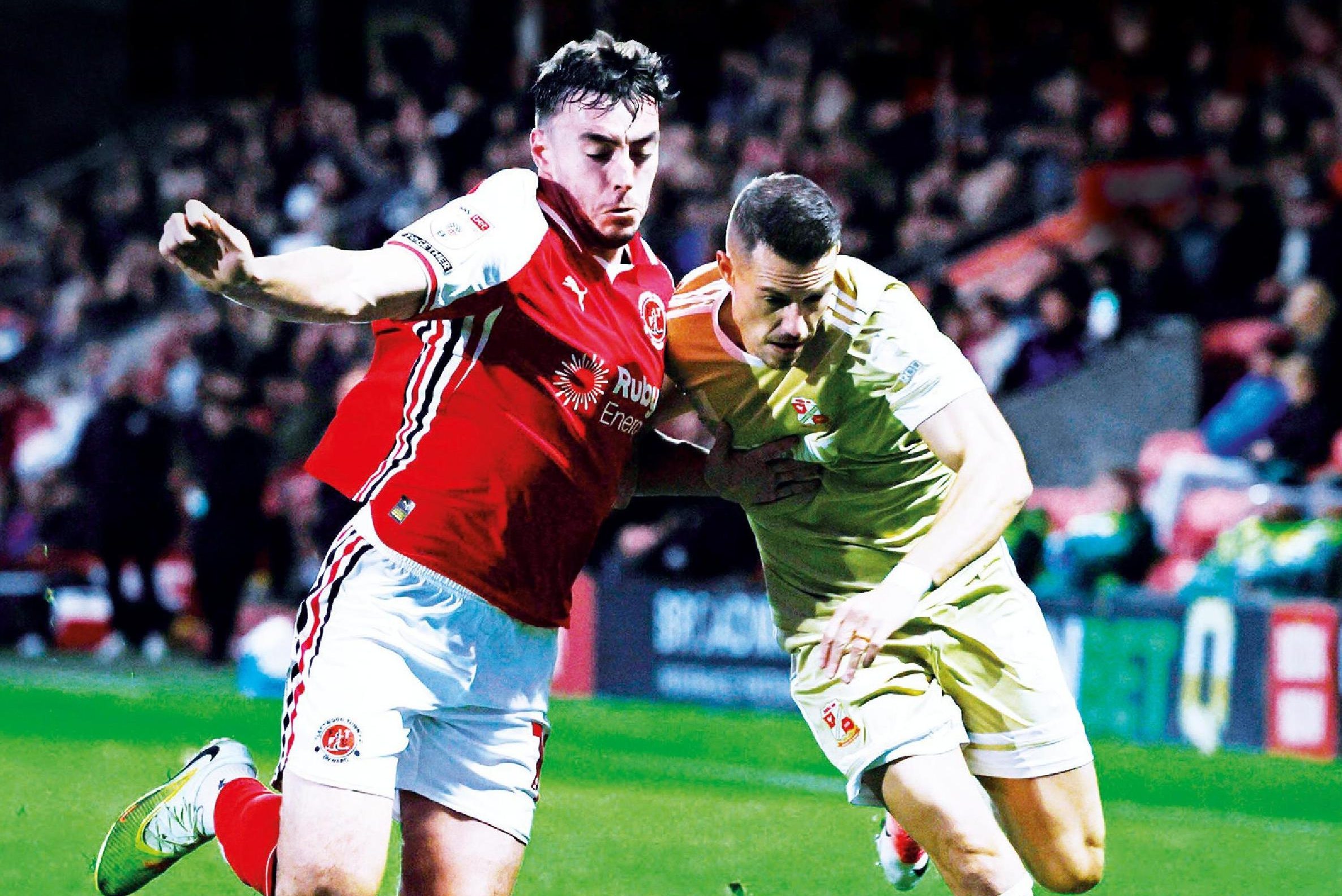 Fleetwood’s Harrison Holgate, left, and Swindon’s Billy Bodin fight it out