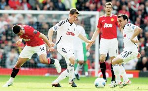 Swansea’s Joe Allen, centre, and Leon Britton, right, in possession against Manchester United