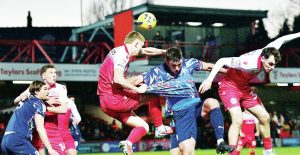 Barrow’s Niall Canavan is sandwiched as he challenges for a header