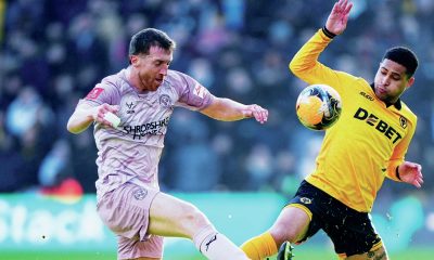 Shrewsbury’s Tom Anderson, left, and Wolves’ Joao Gomes do battle