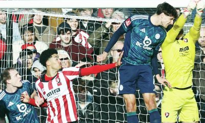 Cheltenham goalkeeper Joe Day punches clear under pressure from Leicester’s Ben Nelson