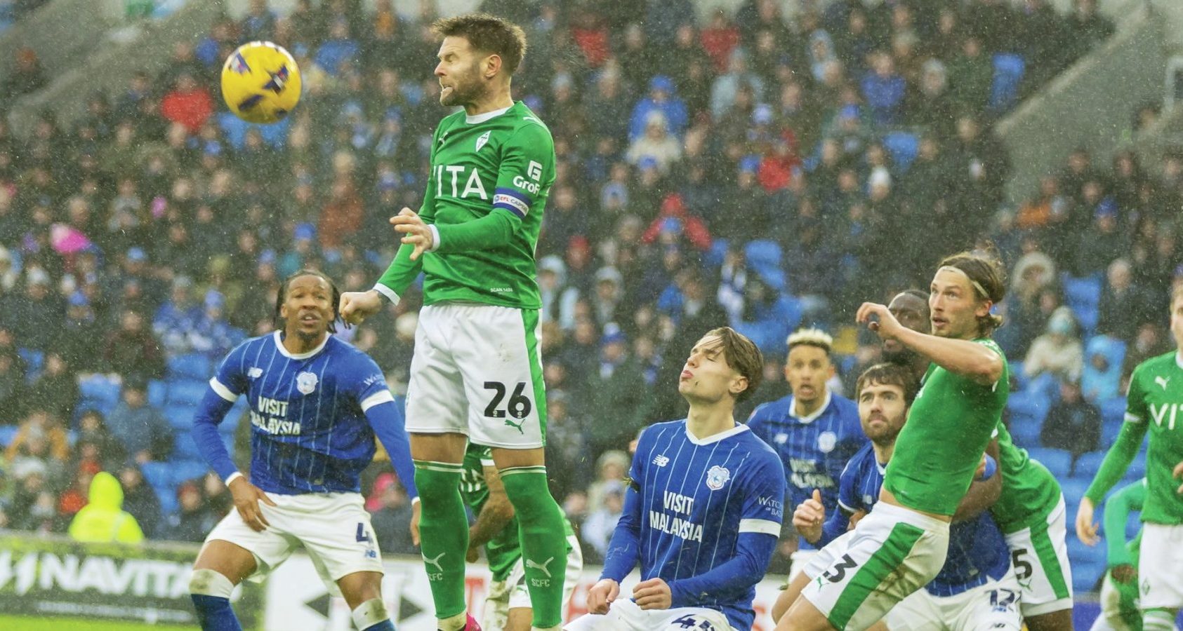 Stockport County midfielder Oliver Norwood rises high and heads clear