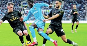 Coventry City attacker Romain Esse is challenged by Oxford United’s Jamie McDonnell, left, and Brodie Spencer