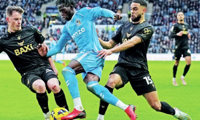 Coventry City attacker Romain Esse is challenged by Oxford United’s Jamie McDonnell, left, and Brodie Spencer