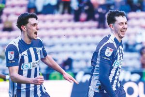 Jensen Weir celebrates scoring his crucial winner with his Wigan Athletic team-mates