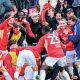 Elated Salford City players and fans celebrate Matt Butcher’s late winner